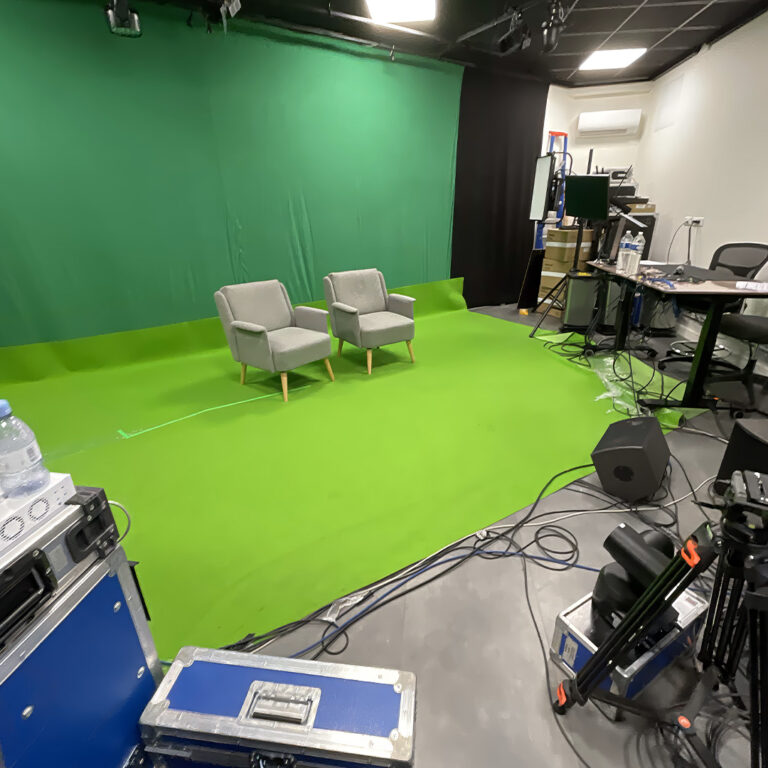 Estúdio com fundo verde chroma key e poltronas para gravação de vídeo corporativo em Belo Horizonte